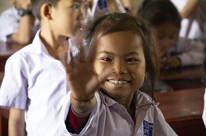 Une enfant souriante tendant la main ouverte d'Enfants d'Asie